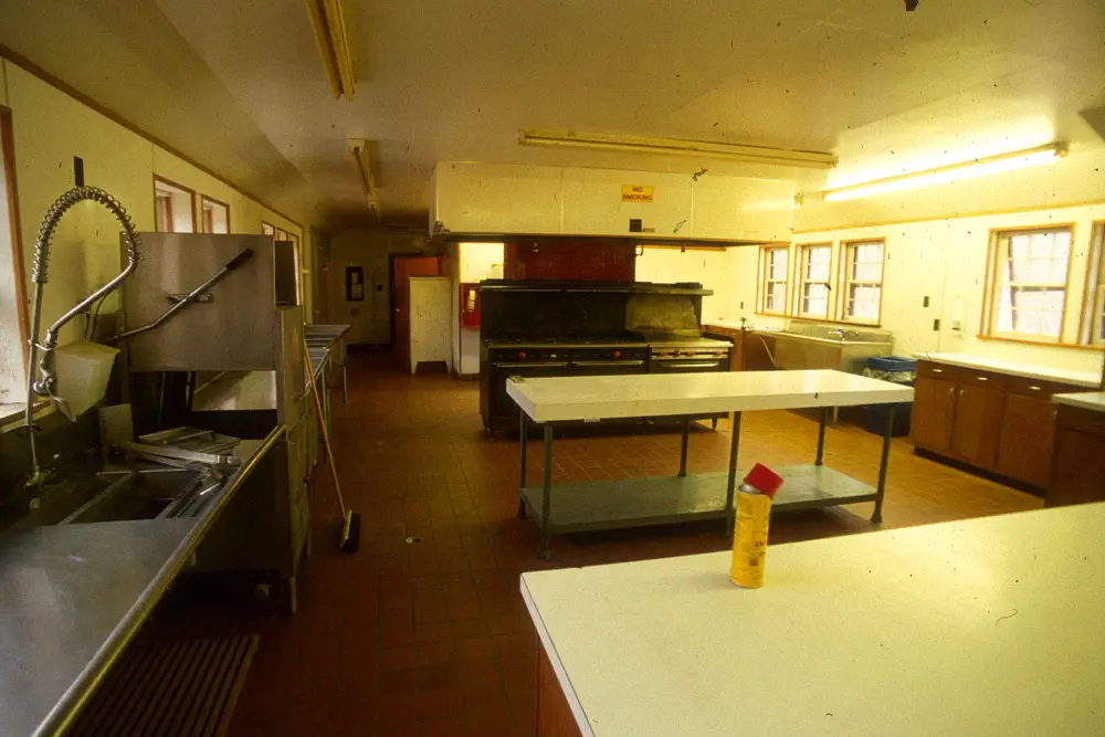 Large commercial kitchen with stainless steel appliances and walk-in refrigeration