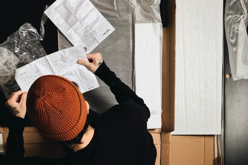 Person reviewing an instruction manual before selecting refrigerant for an air conditioner