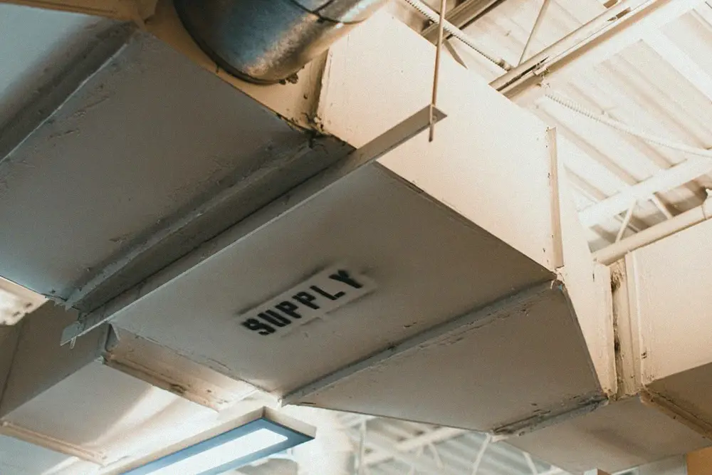 Metal supply-air ductwork connected to an HVAC system where airflow affects replacement-coil performance