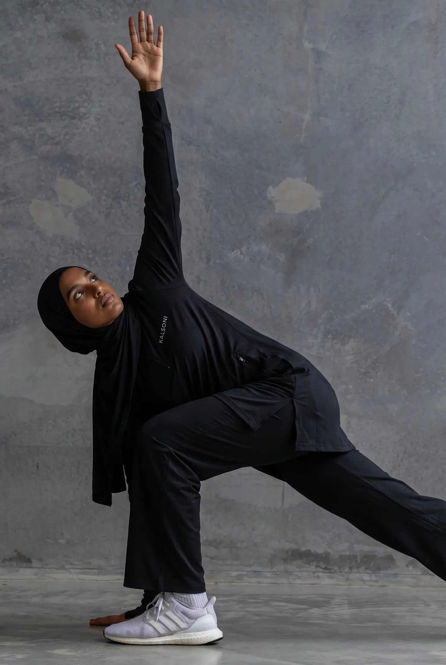 Woman stretching in black Kalsoni performance apparel