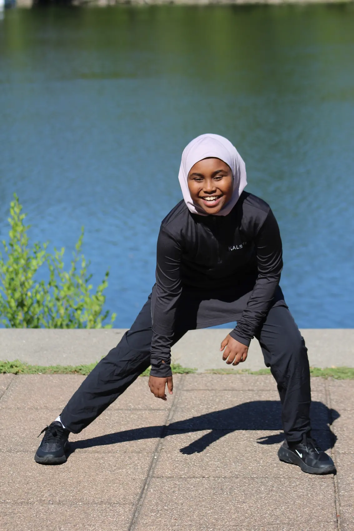 Woman stretching outdoors in Kalsoni performance apparel