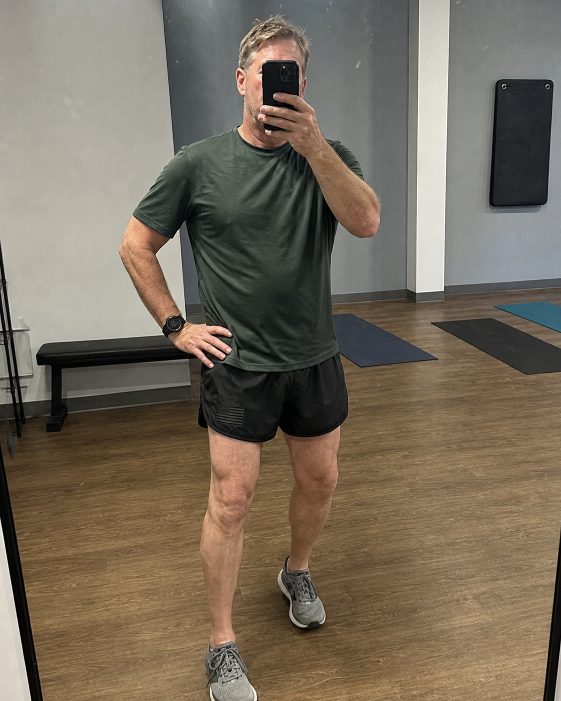AI style inspiration mirror fit wearing Black performance running shorts in a dry fitness studio