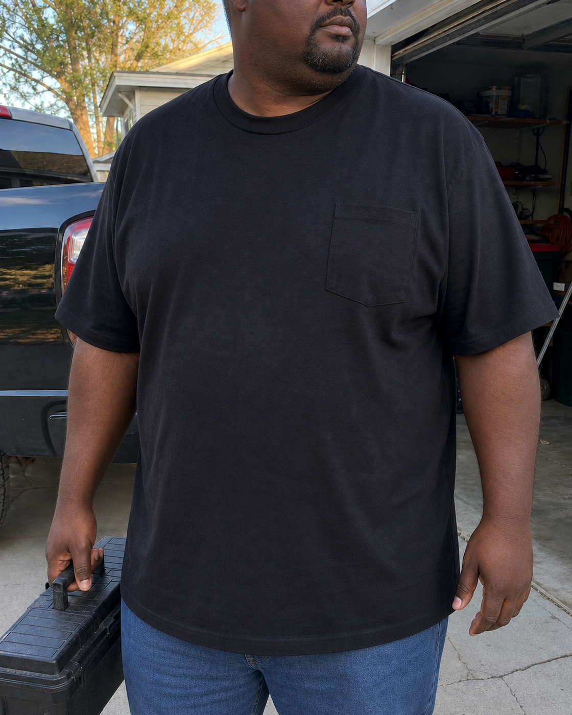 AI style inspiration wearing a Black heavyweight Big and Tall pocket T-shirt beside a garage and pickup truck