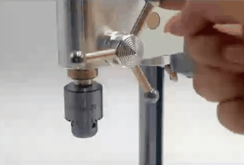 Hand turning the speed control handle on the drill press