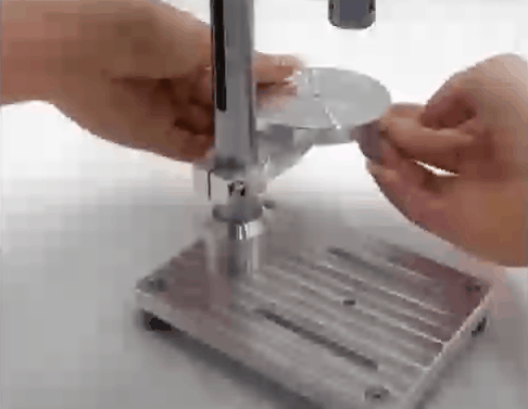 Hands adjusting the round worktable and column of the drill press
