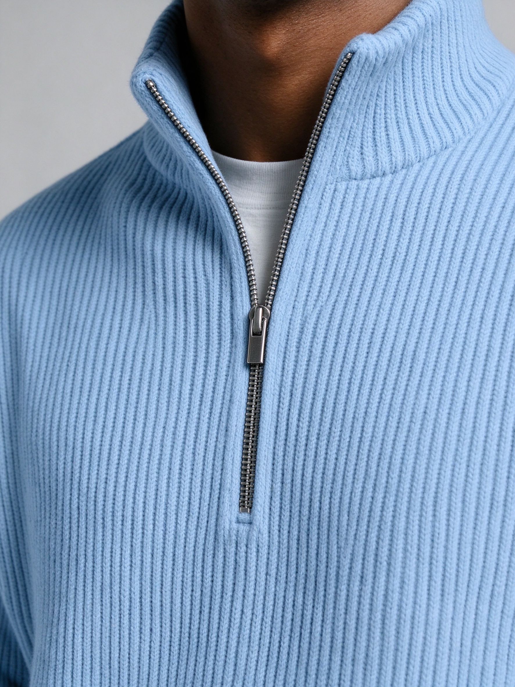 Close-up of metal half-zip and vertical ribbed knit