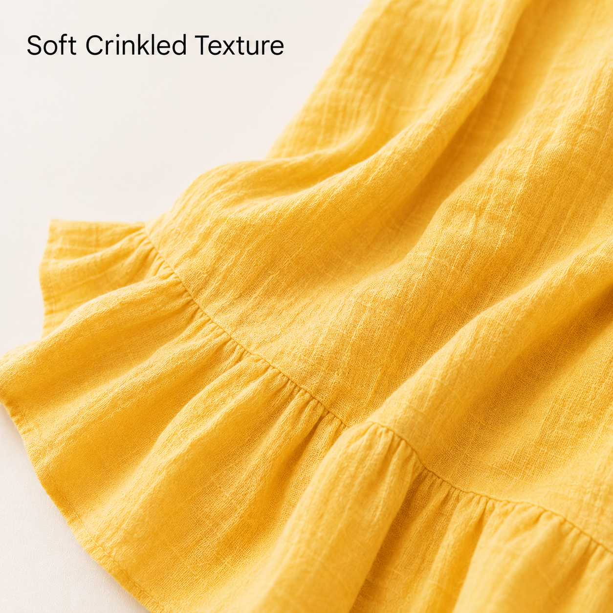Close up of soft crinkled texture on yellow ruffle hem mini dress