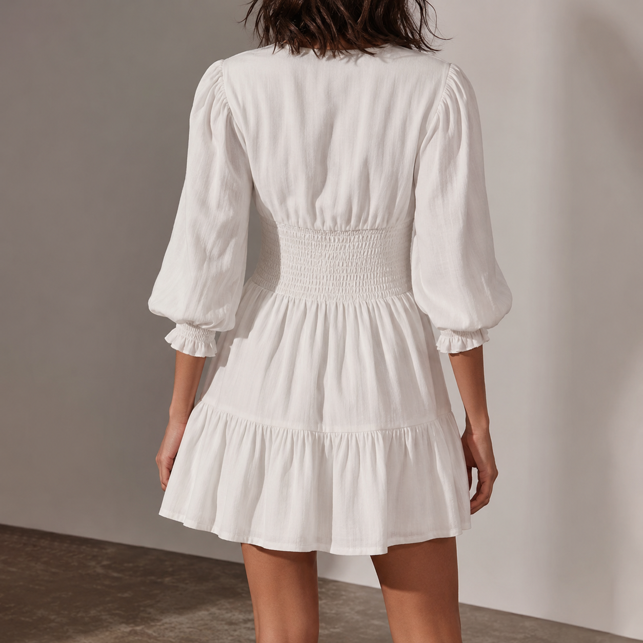 Back view of white smocked waist puff sleeve mini dress