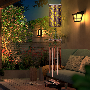 Outdoor patio scene at night with decorative lighting. Illuminated lanterns on wall, string lights overhead, and potted plants create a cozy atmosphere.
