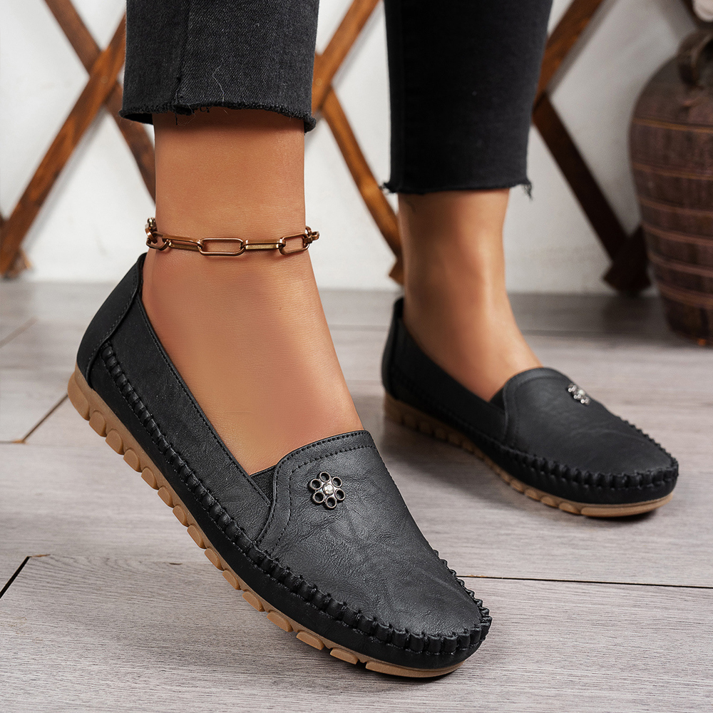 Black slip-on shoes worn on feet