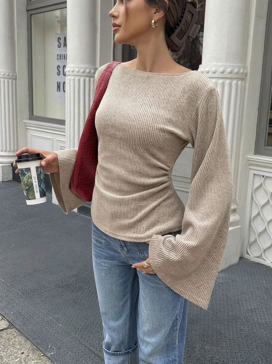 Solid color flared long-sleeve top with off-shoulder neckline and cinched waist