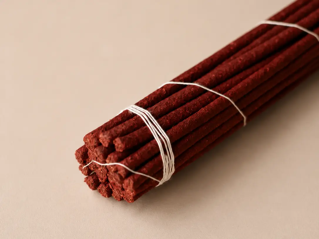 Bundle of reddish-brown Nyang Dey 30 incense sticks tied with white thread, shown diagonally
