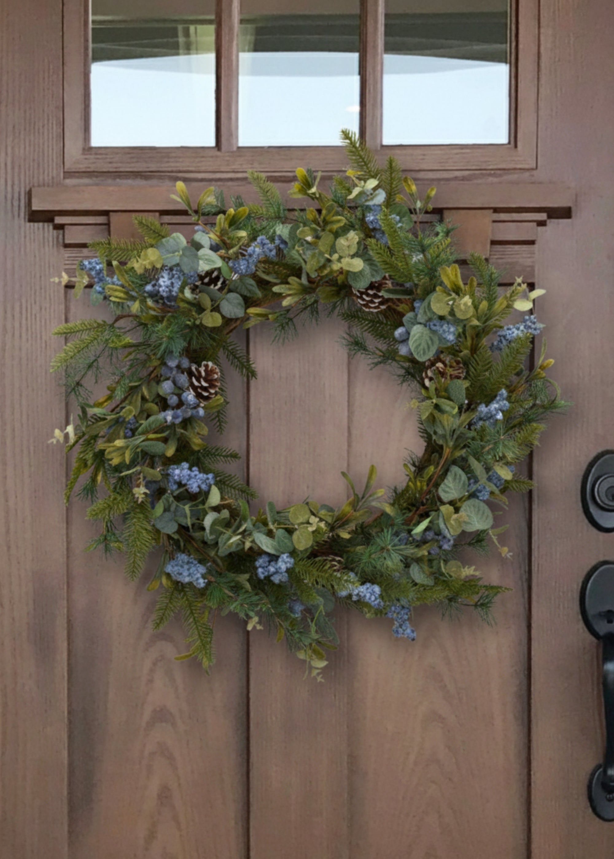 Pine Wreath with Blue Berries on a Wood Door