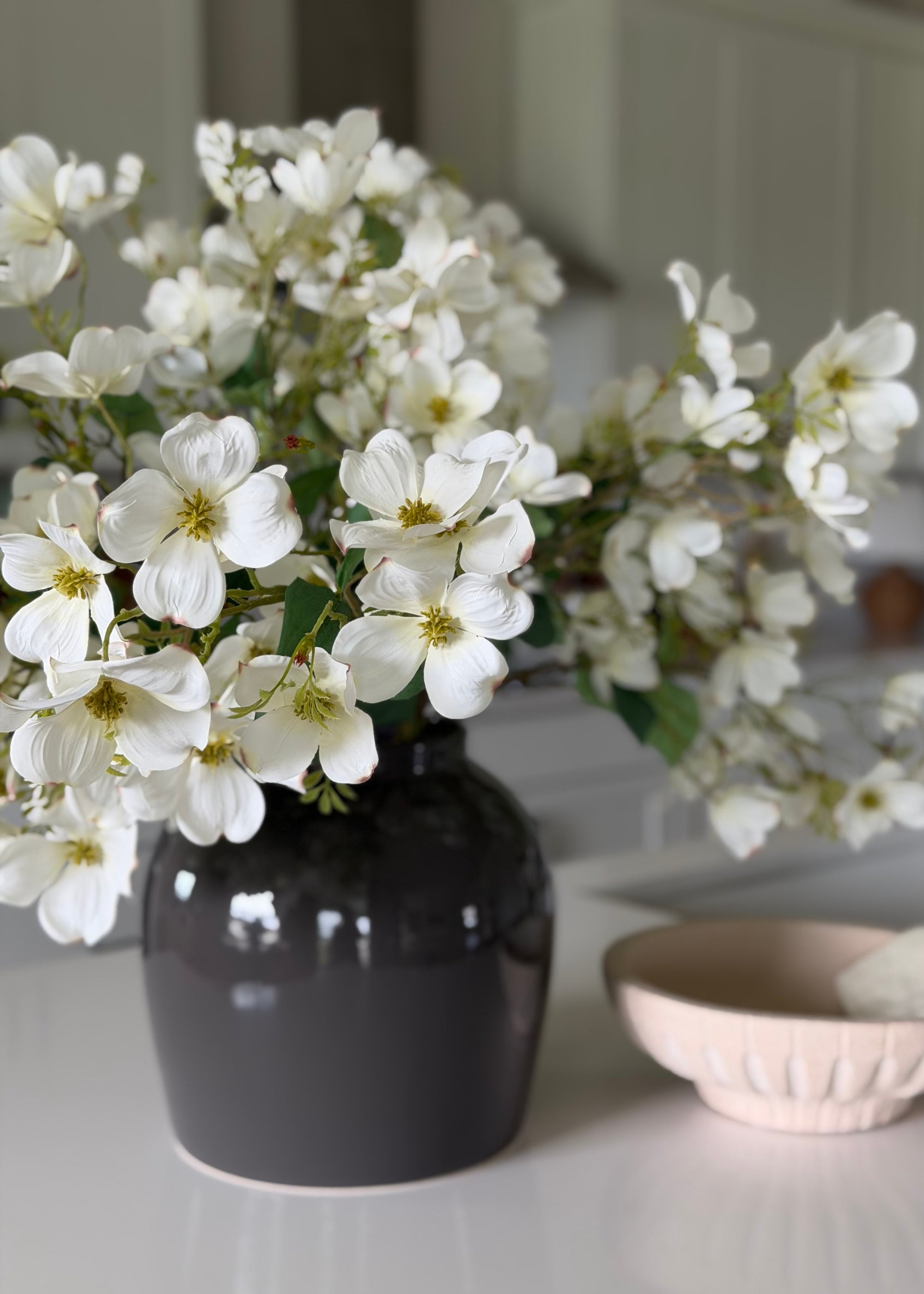 faux dogwood branches in a gray vase