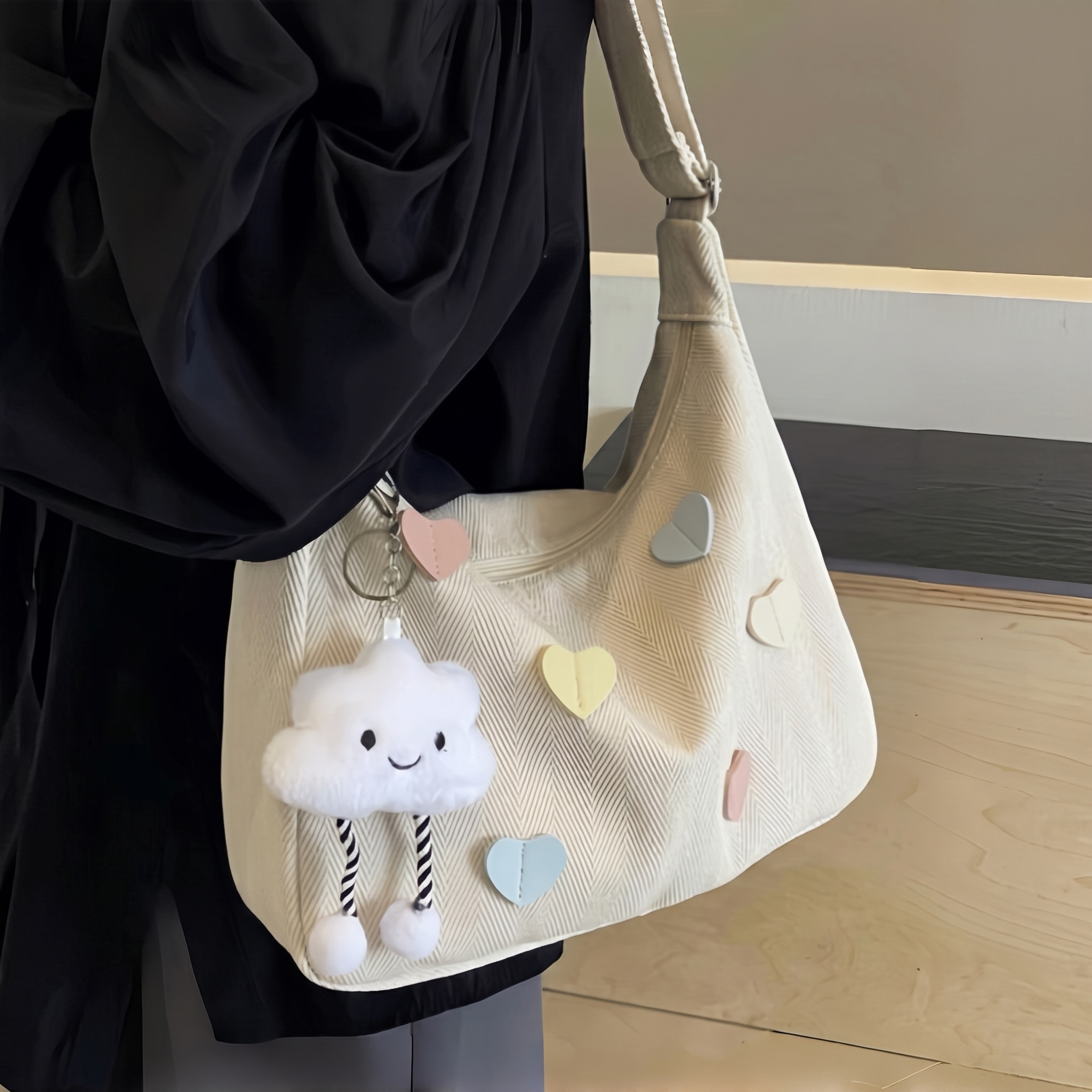 Cream-white textured shoulder bag accented with heart motifs.