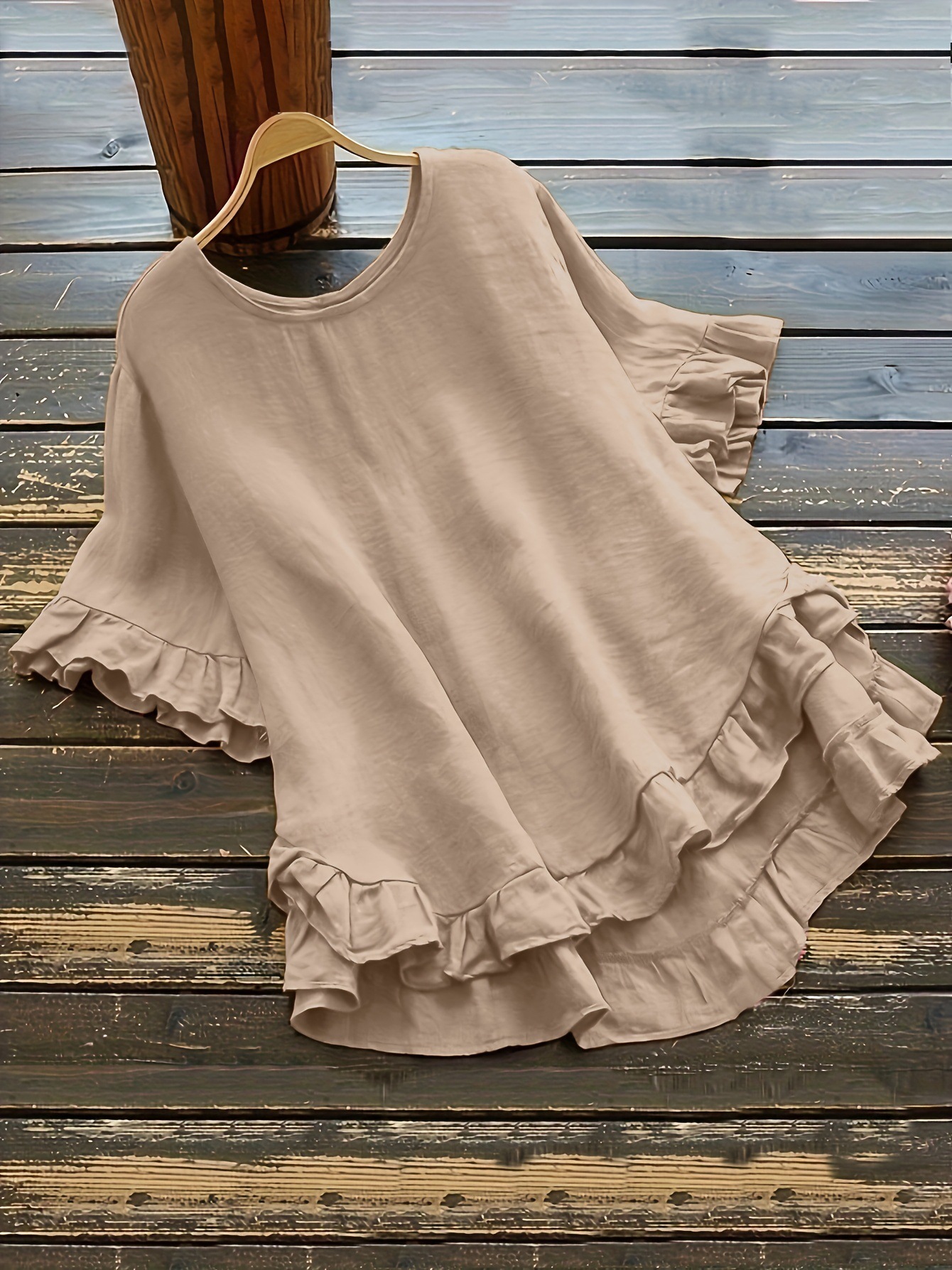 Buttonless ice silk ruffled hem top with front short and back long design, bell sleeves, and round neck