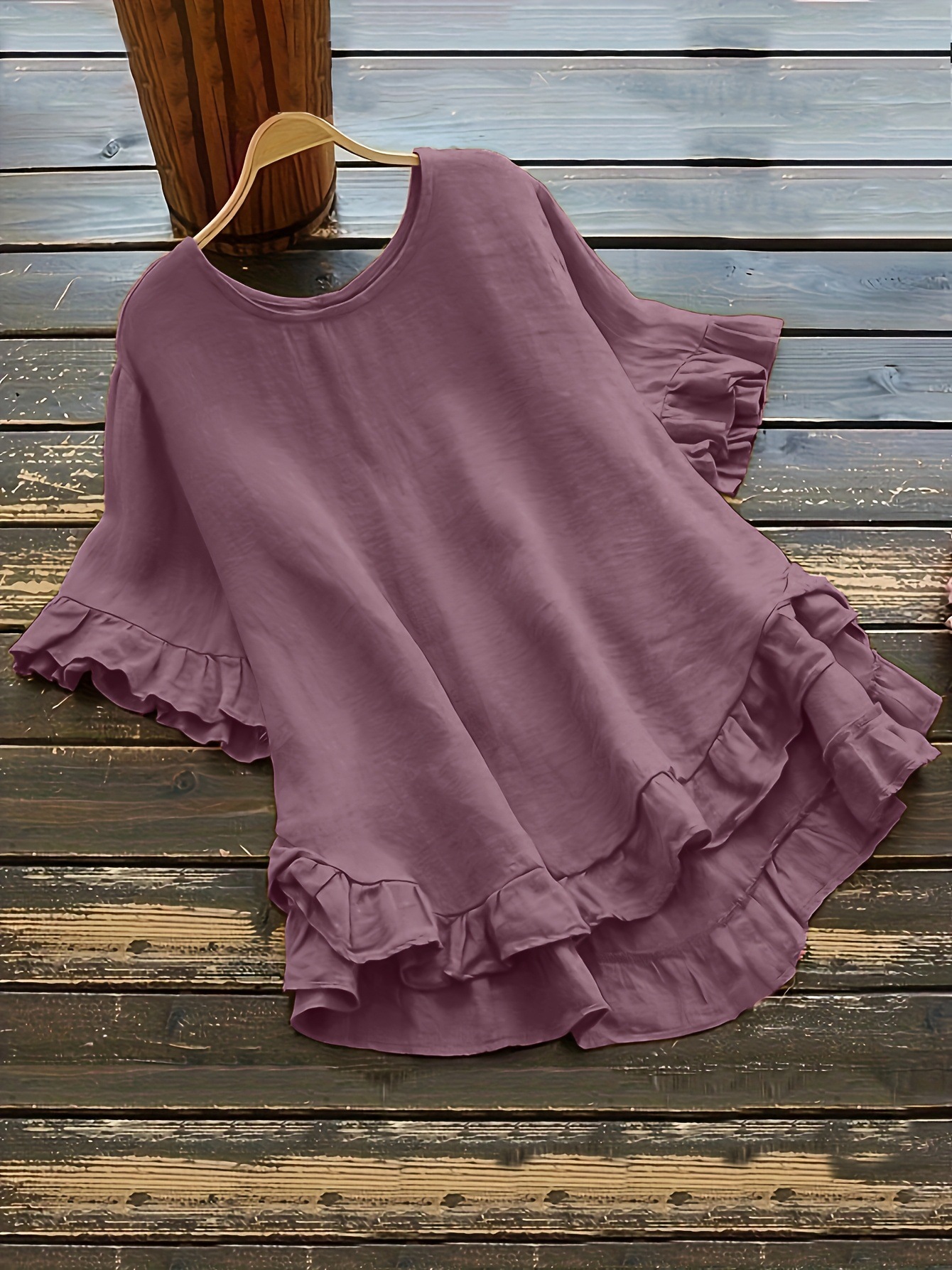 Buttonless ice silk ruffled hem top with front short and back long design, bell sleeves, and round neck