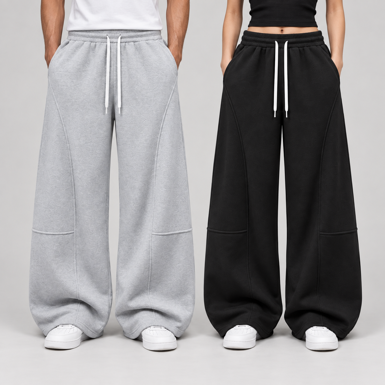 Waist-down front view of unisex baggy wide-leg sweatpants showing drawstring, pockets, and curved seams.