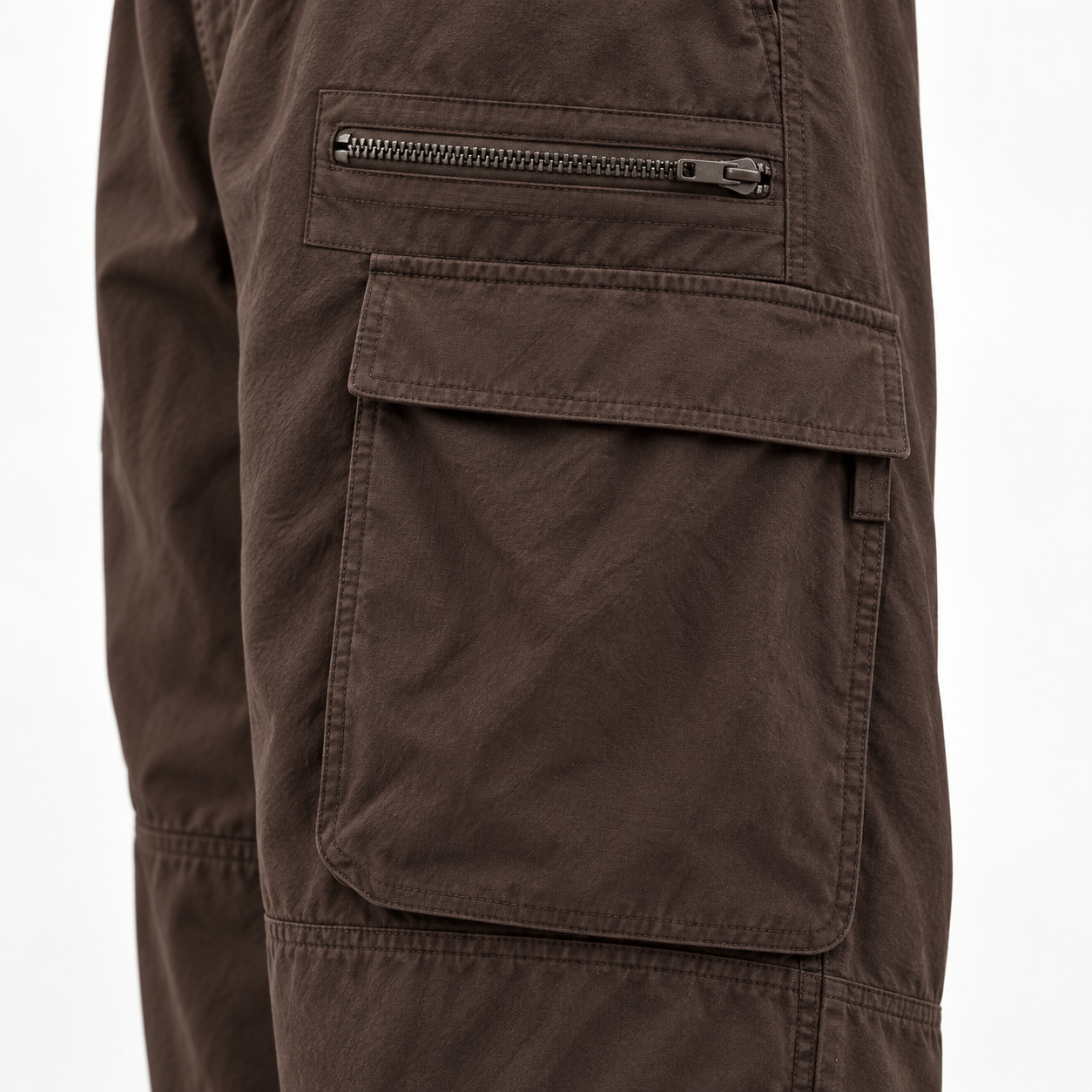 Close-up of the cargo pants zipper pocket, flap pocket, stitching, and woven fabric