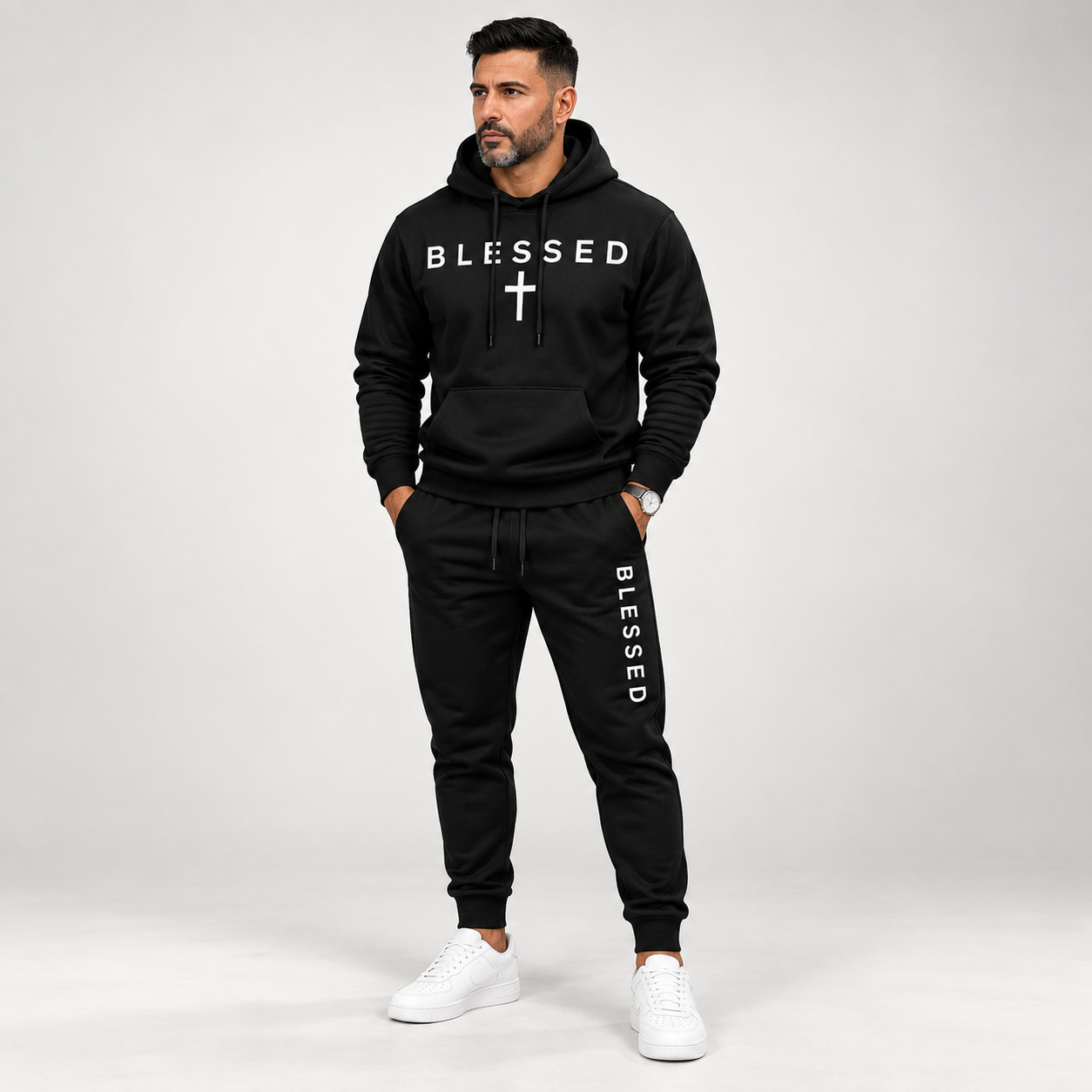 Front view of an adult male wearing the black two-piece hoodie and jogger tracksuit