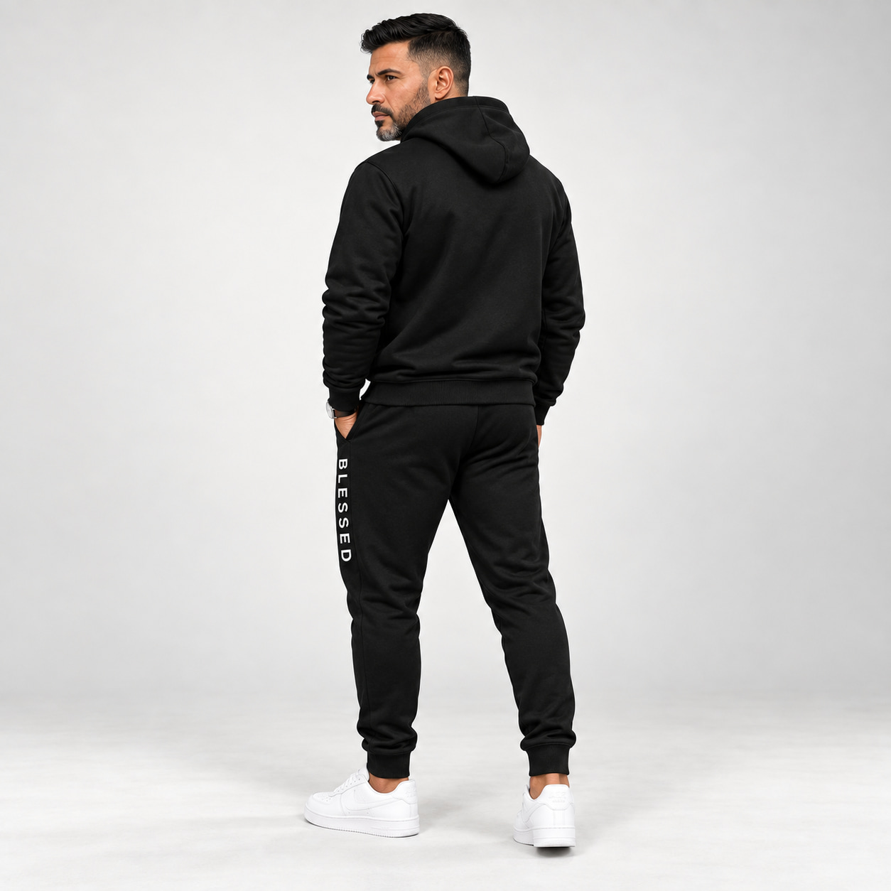 Three-quarter back view of the black hoodie and jogger tracksuit