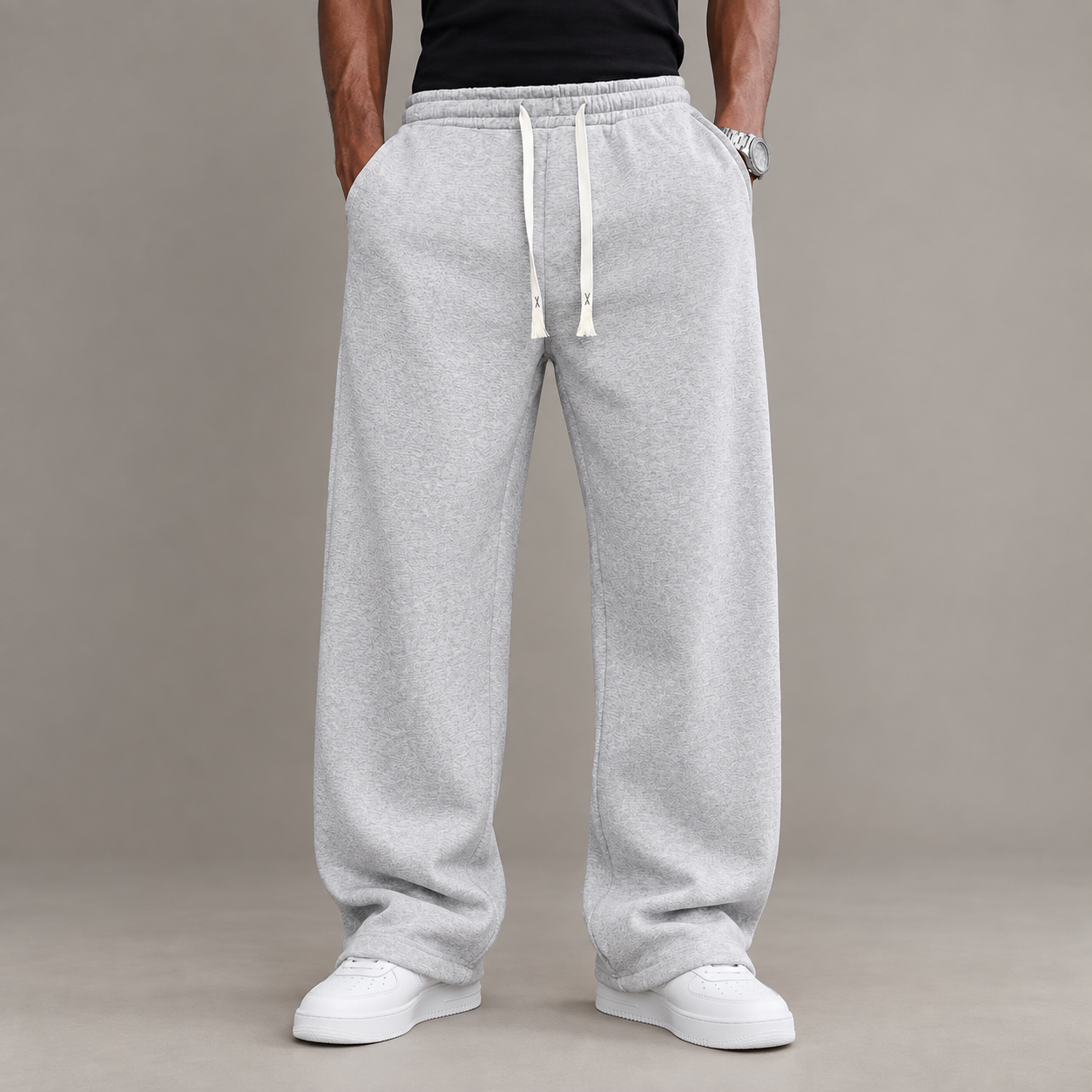 Front view of an adult male wearing full-length gray relaxed straight-leg drawstring pants