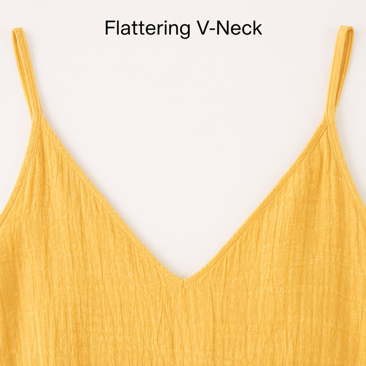 Close up of V-neckline and thin strap detail on yellow crinkled mini dress