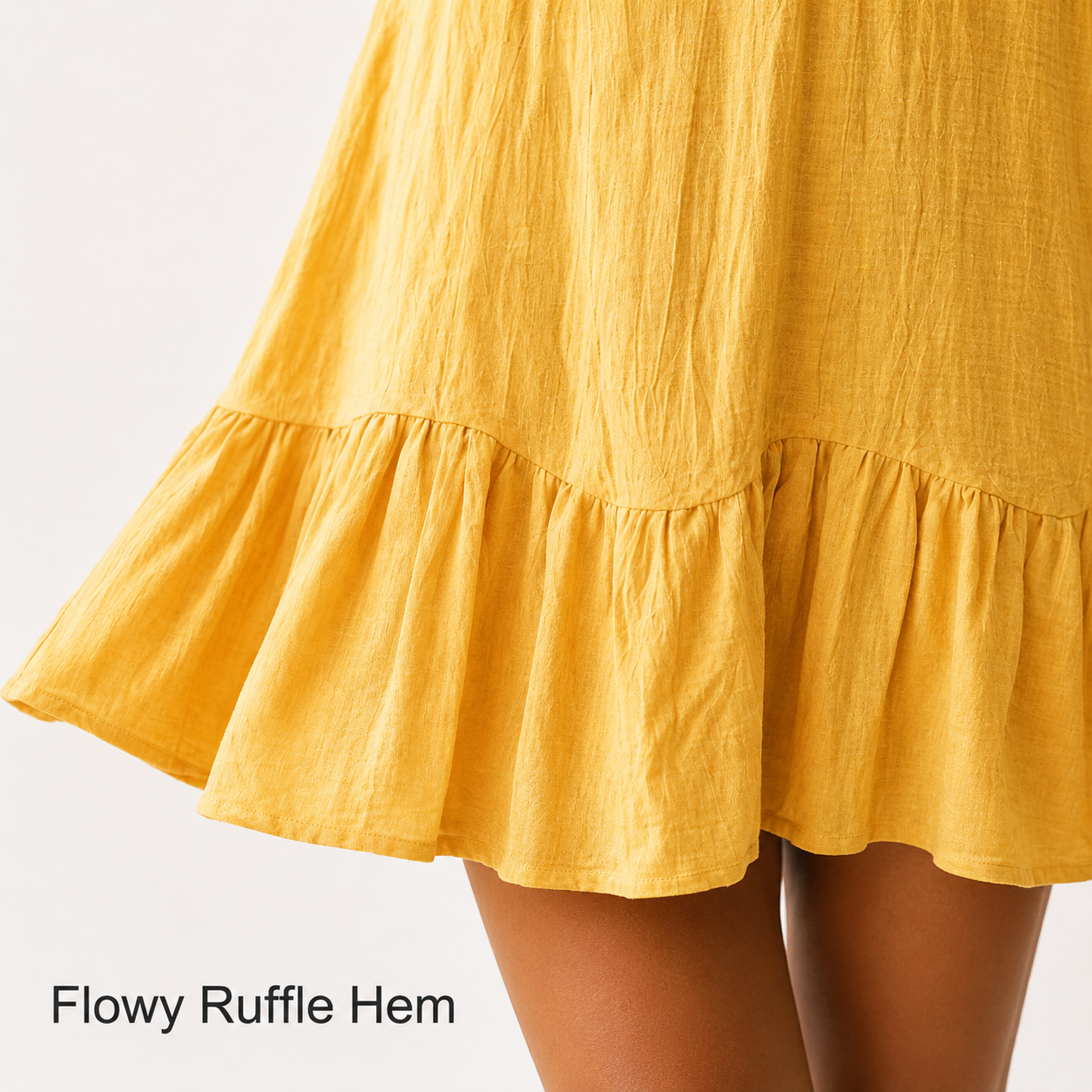 Close up of gathered ruffle hem on yellow mini dress