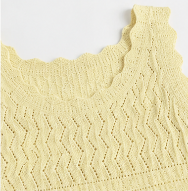 Close detail of the scalloped neckline and upper chevron open-knit pattern