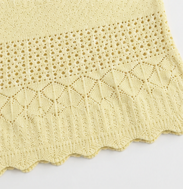 Close detail of the lower knit motif zoning and scalloped hem