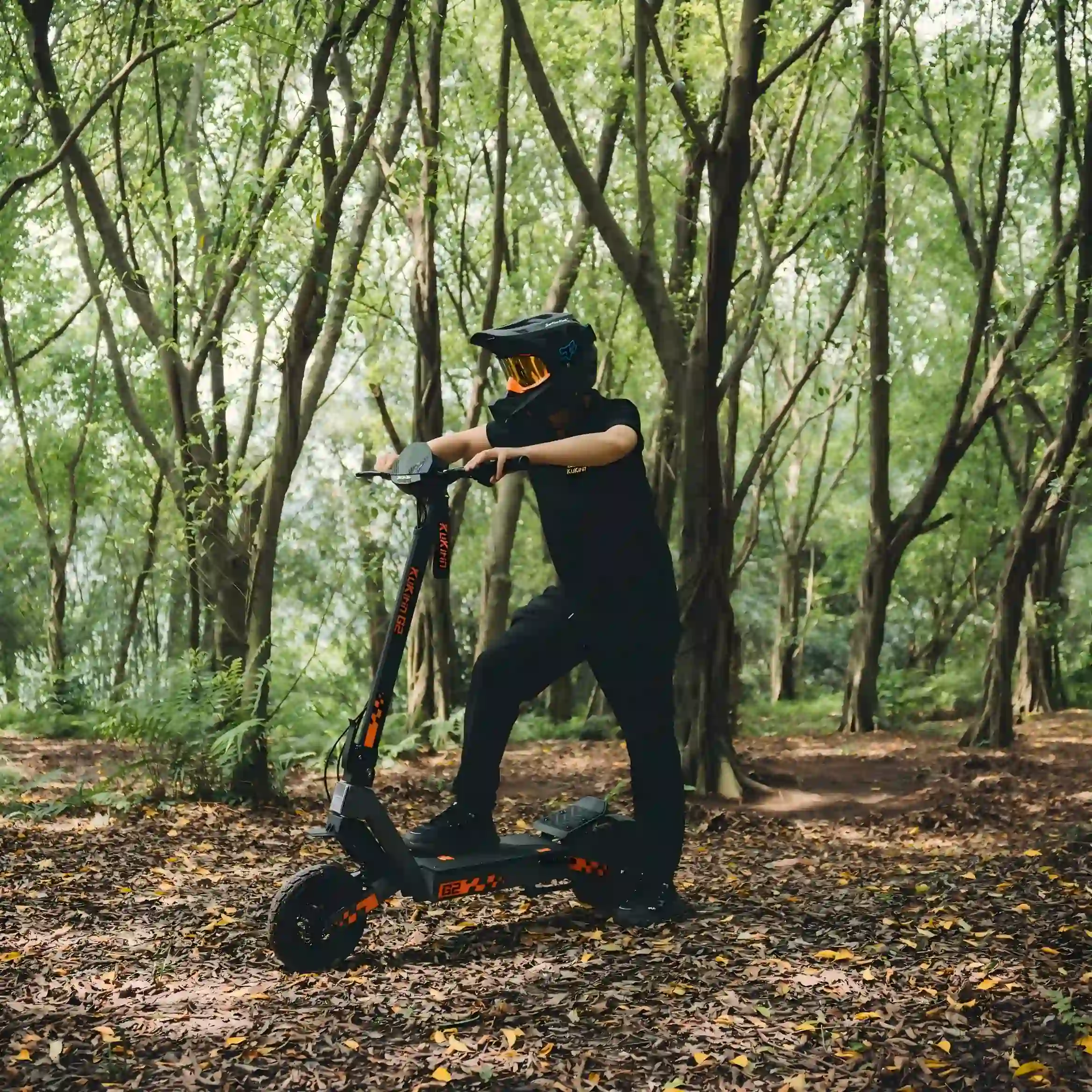 Kukirin G2 light off-road riding scene on forest path, rider in protective gear, four-arm shock absorption system, 800W motor, 48V 15.6Ah battery, 45km/h max speed, 55km max  range, all-terrain capability, global kukirin