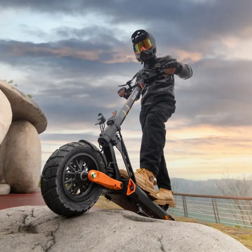 KuKirin G2 Pro VMP being ridden on a rocky outdoor platform, highlighting its thick knobby tires, front suspension, and ability to handle rough terrain. Sunset sky and scenic backdrop, 500w motor, 48V 15.6Ah battery, 25km/h max speed, 65km max range,global kukirin