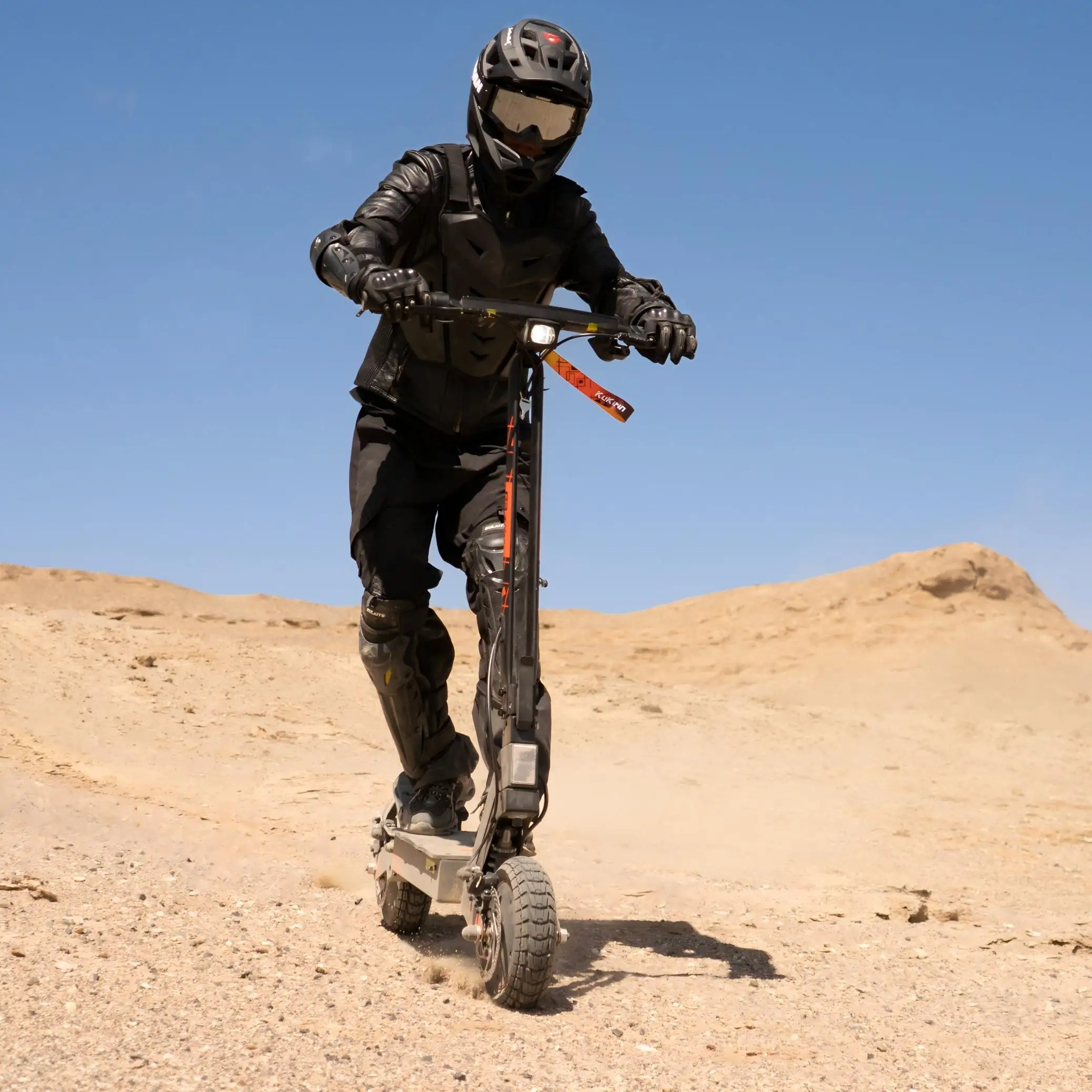 Kukirin G2 Ultra desert dune off-road riding scene, rider in full protective gear, dual motor kicking up dust, all-terrain capability, 26° climbing ability, 800W*2 motor, 48V 18Ah battery, 50km/h max speed, 55km range,global kukirin
