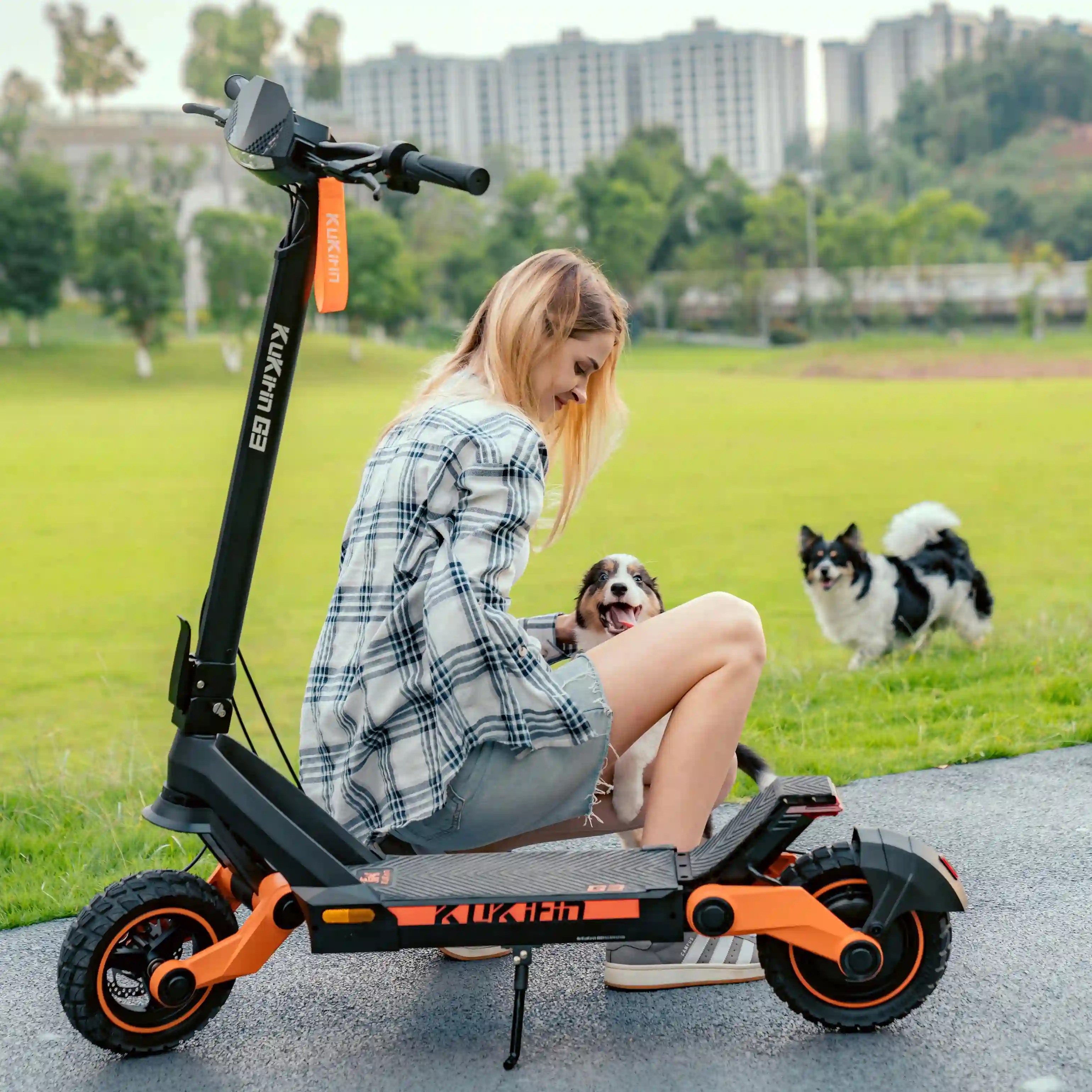 Kukirin G3 lifestyle scene at city park with dogs, woman relaxing beside the scooter, showing its casual daily use, foldable design and wide deck, perfect for urban and park trips,1200W motor, 52V 18.2Ah battery, 50km/h max speed, 63km range, global kukirin