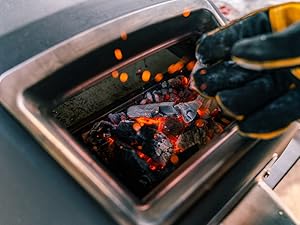 Charcoal embers glowing in the fuel tray