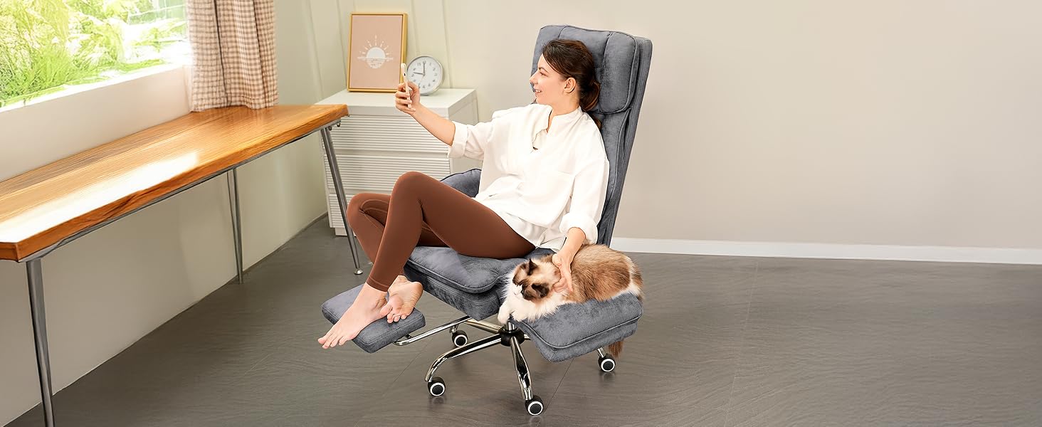 Woman taking a selfie with a fluffy cat sitting beside her on the wide chair seat