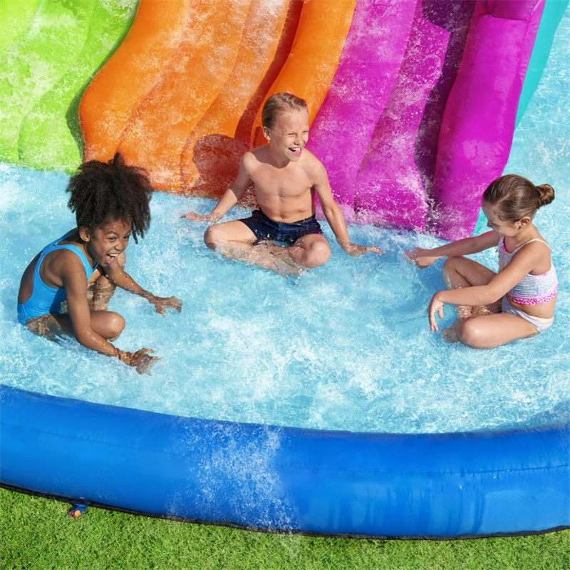 Three children playing together in the extra-large splash pool at the base of the water slides