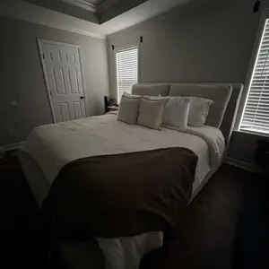 Made bed with upholstered headboard and styled bedding