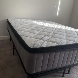 Mattress on black metal frame showing quilted top texture
