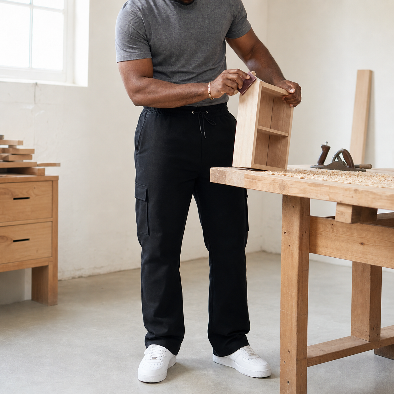 Black cargo pants in a bright woodworking scene