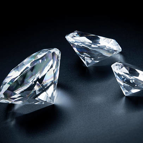 Three faceted diamonds on a dark background