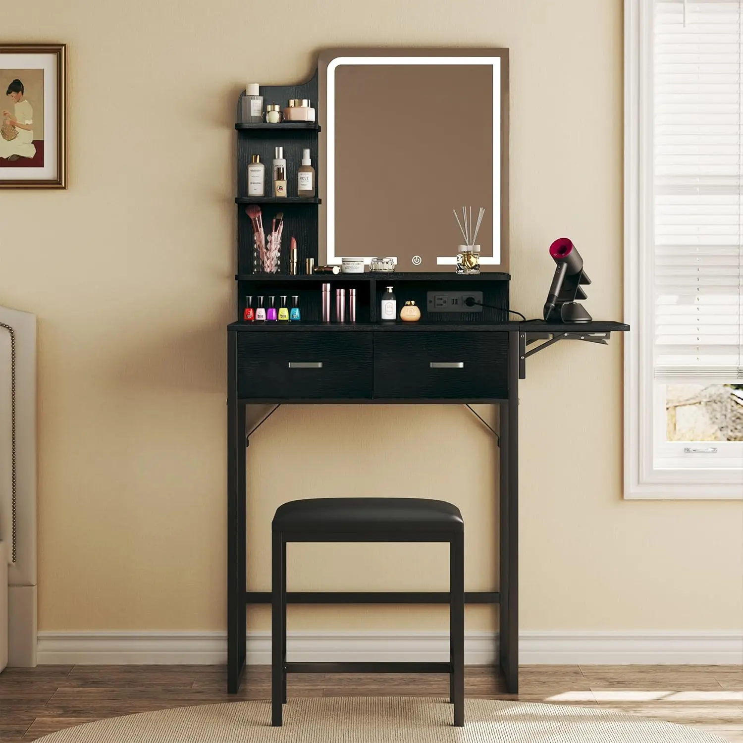 Un tocador con espejo y luz; un tocador pequeño con cajones de tela, una silla y estantes; con un panel plegable y una toma de corriente.