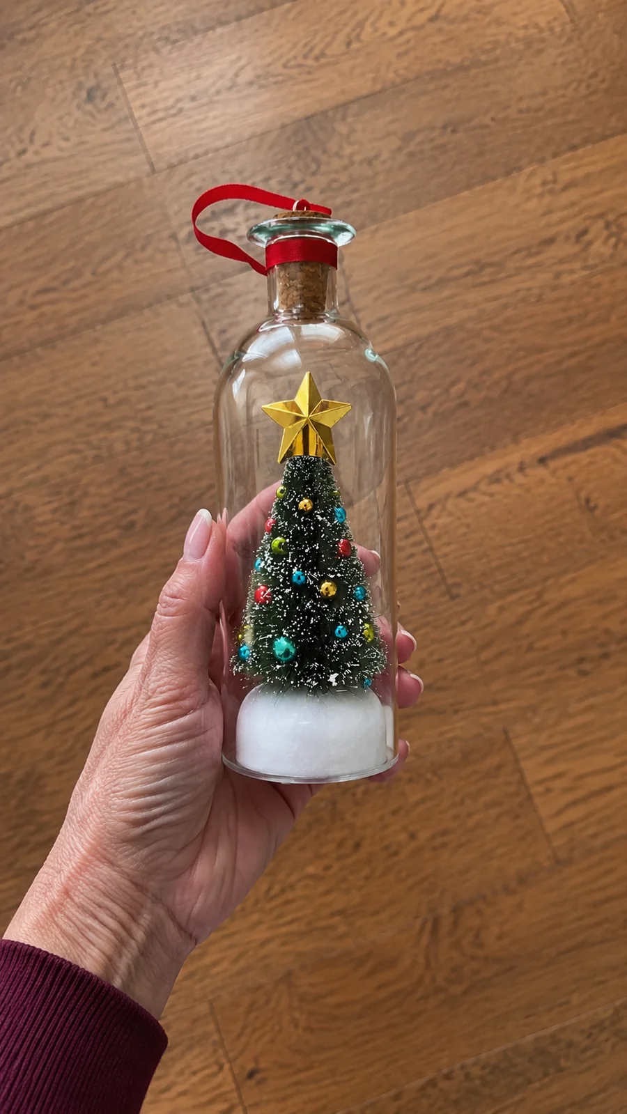 Customer holding the green Christmas voice message bottle