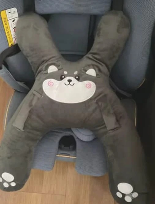 Customer photo showing the gray puppy pillow's plush shape and embroidered details