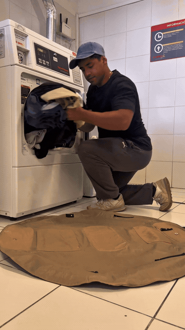 Lay-flat tote collecting laundry beside a washing machine