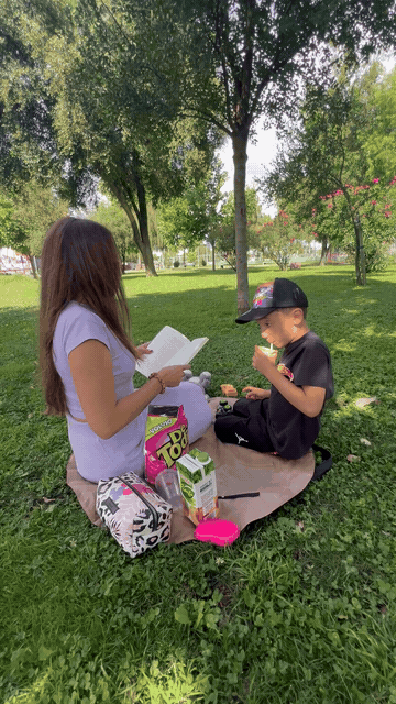 A couple using the opened tote during a park picnic