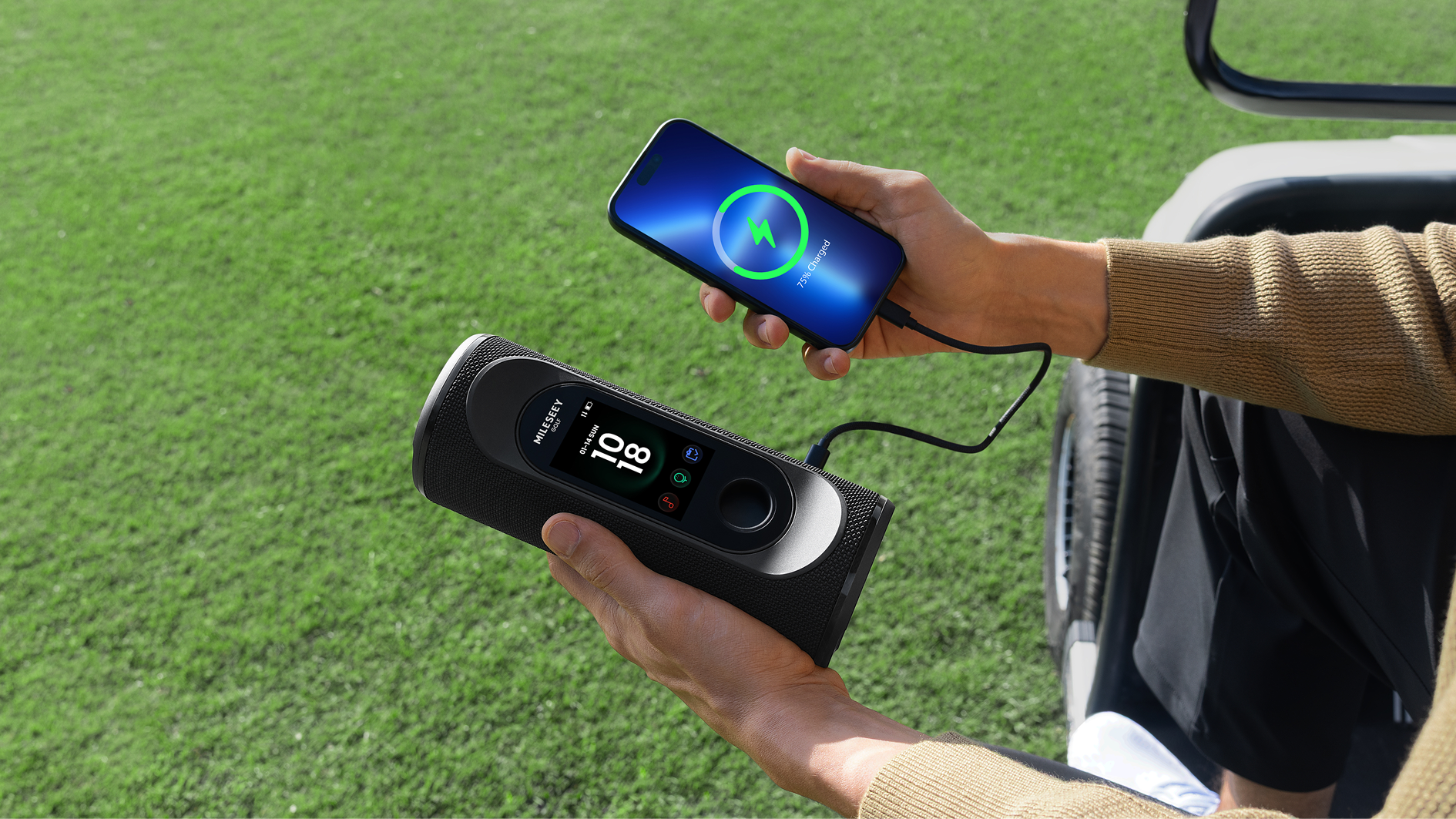 A Man Sitting on Golf Cart and Using GeneSonic Pro GPS Speaker as a Power Bank to Charge Mobile Phone