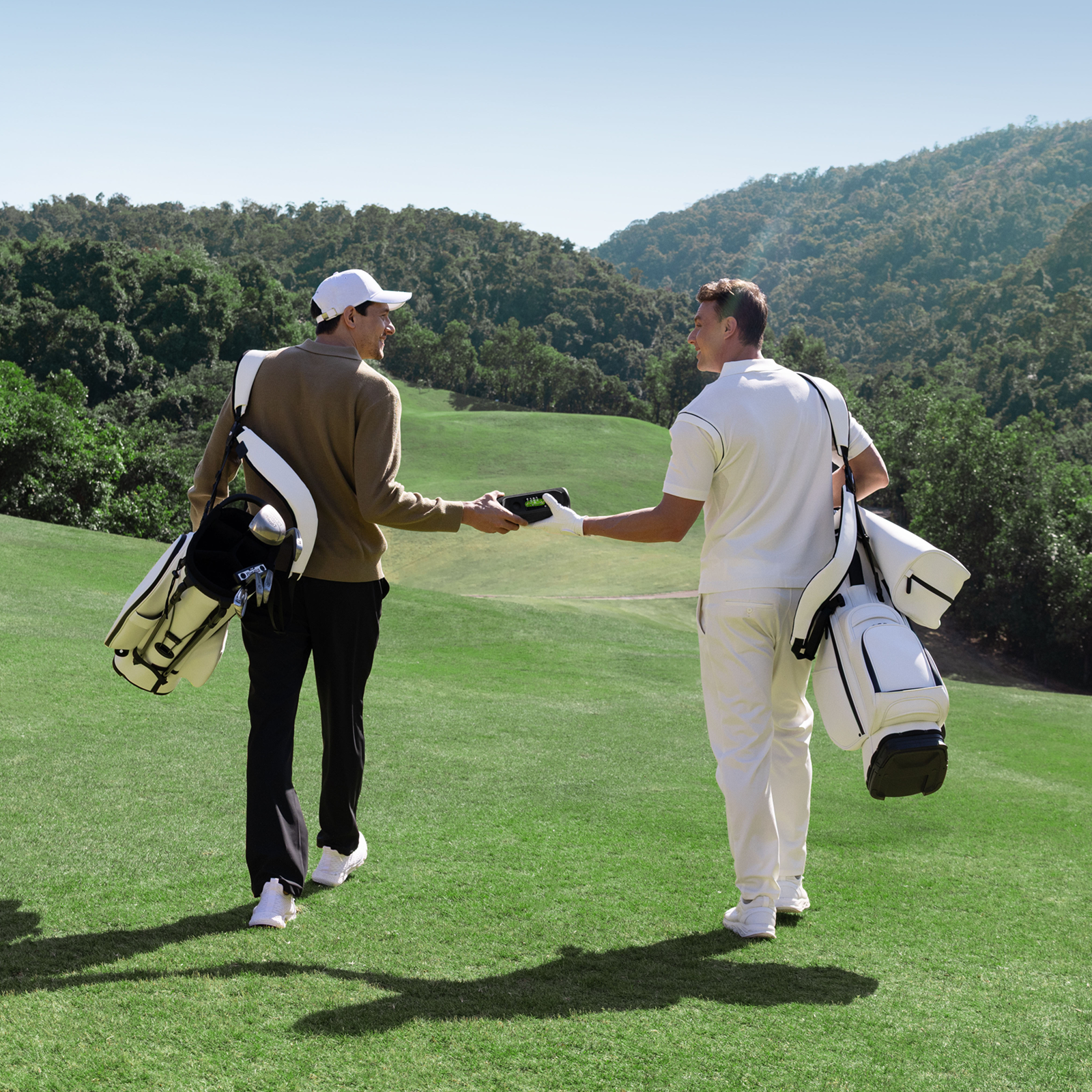 A Golf Man Passing A MILESEEY GeneSonic Pro Detachable GPS Speaker to Another Golf Man