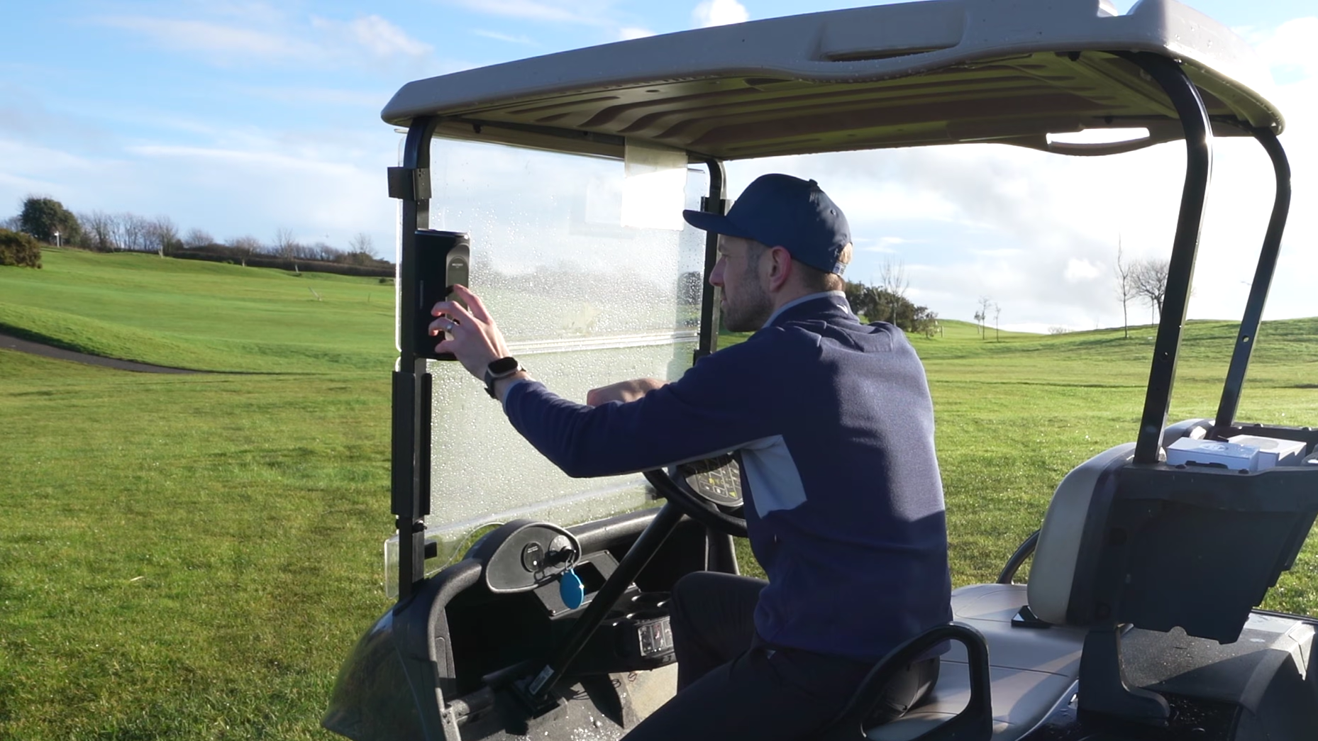 A Man Sitting on Golf Cart and Mounting a GeneSonic Pro Golf Speaker on his Cart