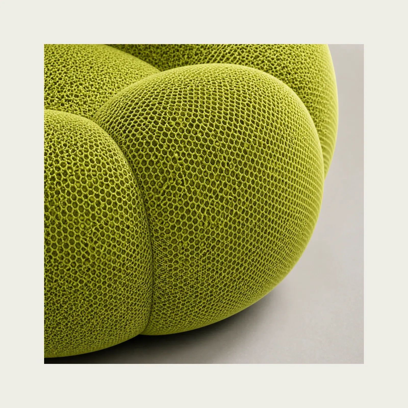 Close view of the green sofa fabric and rounded padded sections